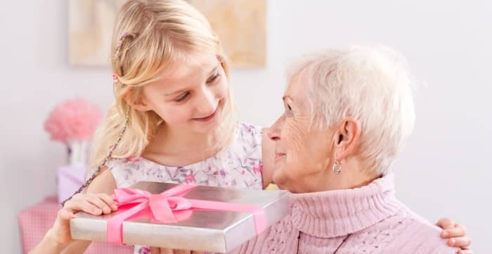 Girl giving gift to older woman