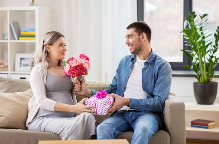 Man giving pregnant wife a valentine gift