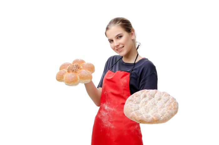 Young female baker isolated on white