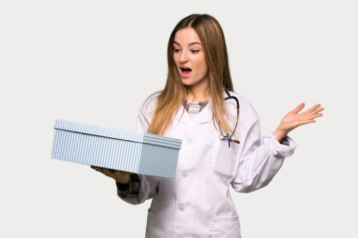 Young doctor woman holding gift box in hands