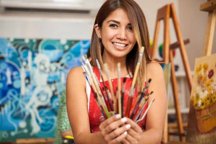 Woman holding art brushes in an art studio