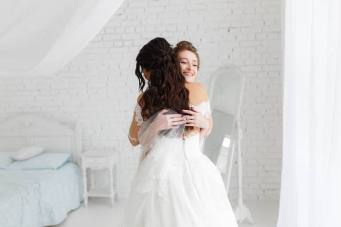 luxury bride hugging bridesmaid and smiling, joyful moment