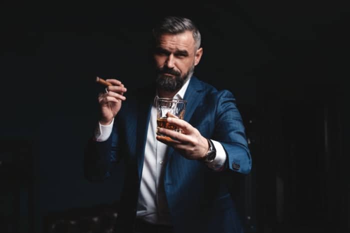 Guy smoking a cigar with a scotch drink