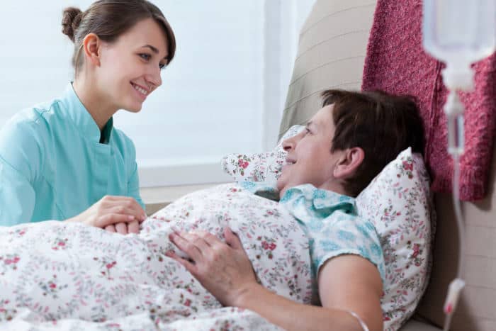 woman talking to another woman who is bedridden