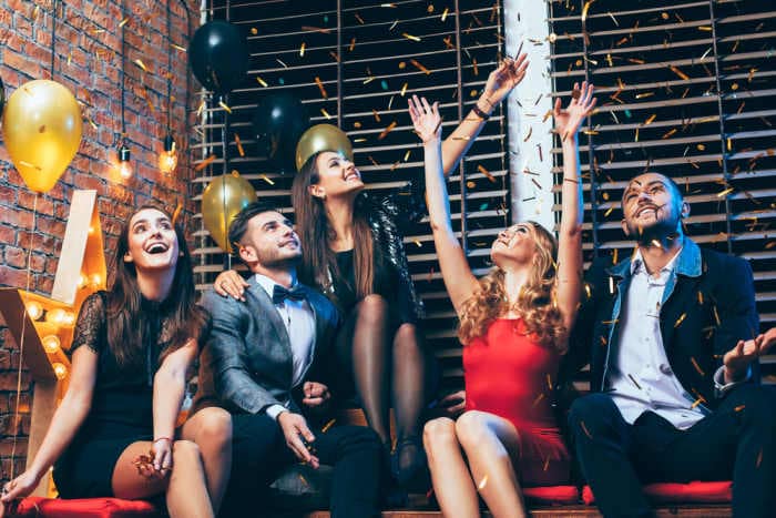Group of friends enjoying party and having fun throwing confetti for Birthday
