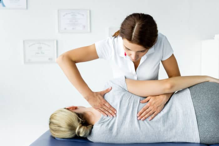 Woman chiropractor working on female patient