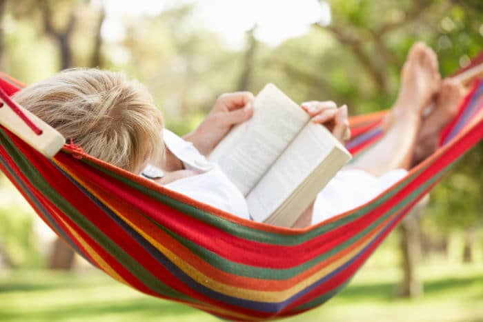 woman reading a book in retirement in a hammock