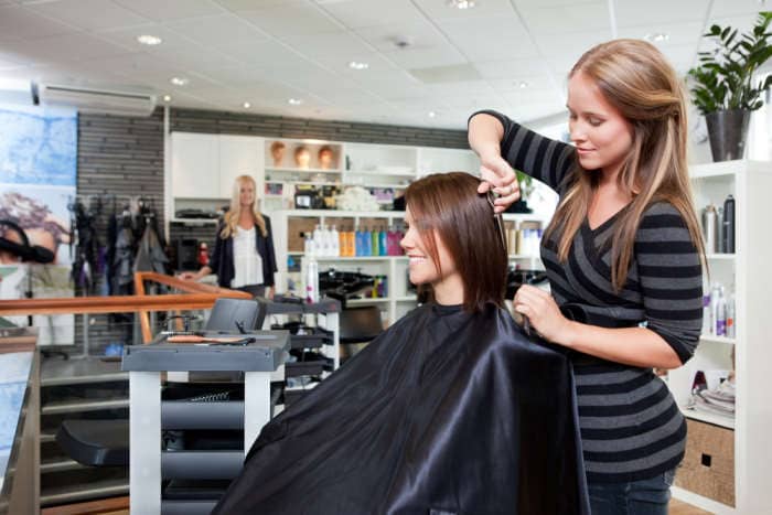 Hairdresser thinning customers hair in beauty salon.