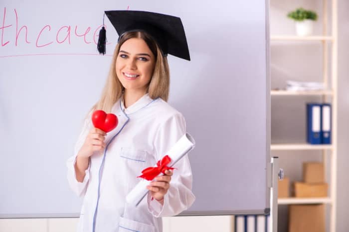 Woman graduating medical school with diploma and plastic heart in hand