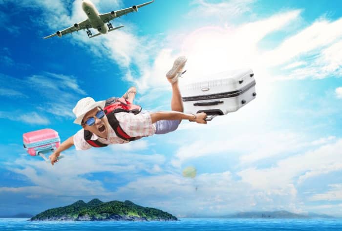 Guy flying through air with suitcases on vacation